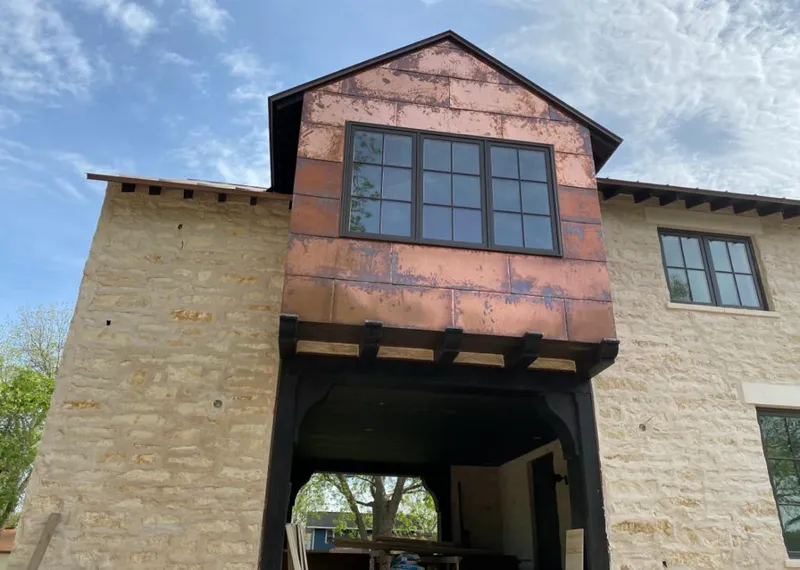 Copper metal panel facade on a stone building for Roof Repair in Edgewood